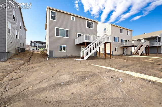 rear view of house with central AC unit and a deck