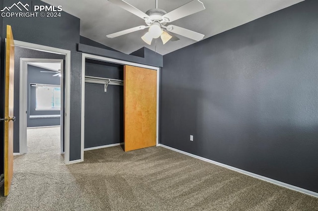 unfurnished bedroom with ceiling fan, a closet, lofted ceiling, and carpet flooring