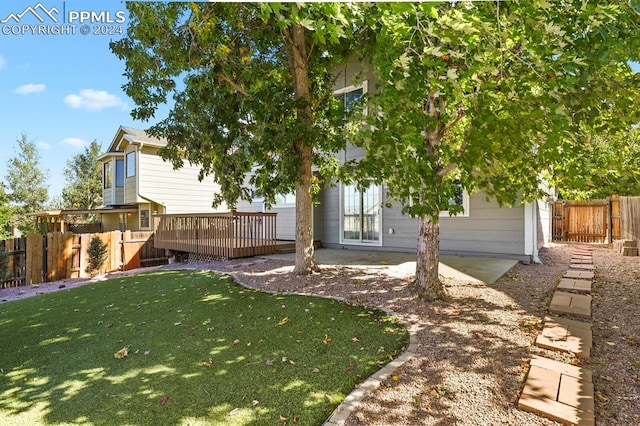 rear view of house with a yard and a deck