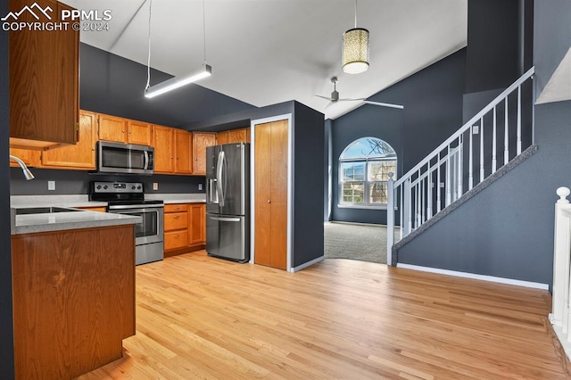 kitchen featuring pendant lighting, light wood-type flooring, sink, high vaulted ceiling, and stainless steel appliances