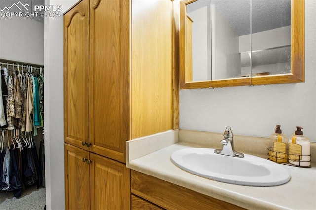 bathroom featuring a textured ceiling and vanity