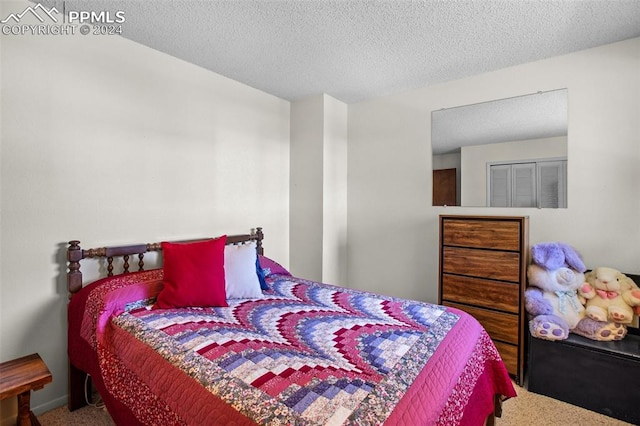 bedroom with carpet floors and a textured ceiling