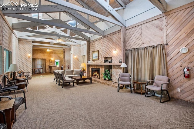 interior space with wooden walls, a fireplace, beam ceiling, and ceiling fan