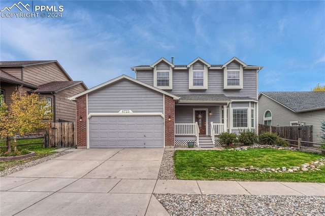 front of property with a front yard, a porch, and a garage