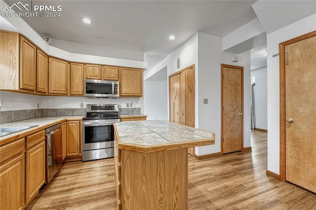 kitchen featuring light wood-type flooring, appliances with stainless steel finishes, and a center island