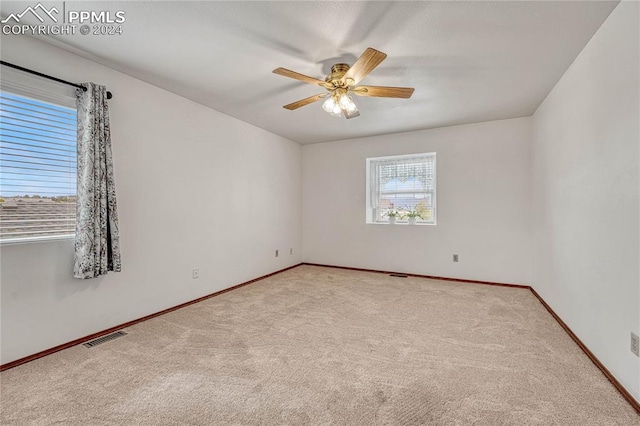 carpeted spare room featuring ceiling fan