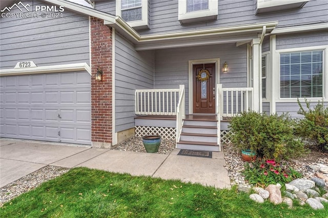 entrance to property with a porch and a garage