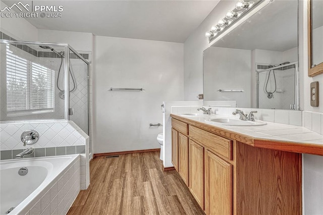 full bathroom with hardwood / wood-style flooring, vanity, toilet, and plus walk in shower