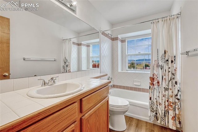 full bathroom featuring wood-type flooring, vanity, toilet, and shower / bathtub combination with curtain