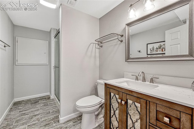 bathroom featuring hardwood / wood-style floors, vanity, toilet, and walk in shower