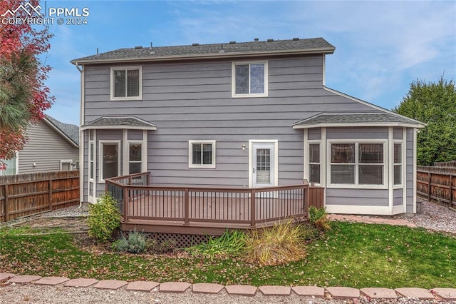 back of house featuring a wooden deck and a yard