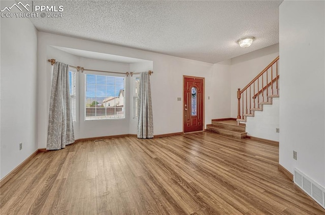 entryway with a textured ceiling and hardwood / wood-style flooring