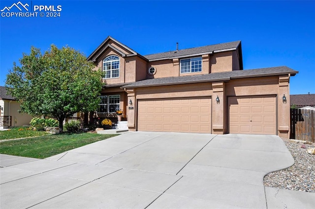 view of front of property featuring a front yard and a garage