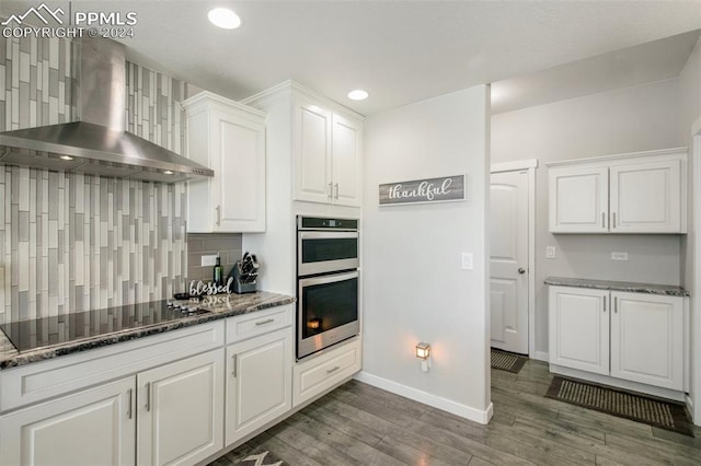 8032 Wheatland Dr, Colorado Springs, CO 80908 - kitchen with baseboards, wall chimney exhaust hood, double oven, wood finished floors, and black electric stovetop