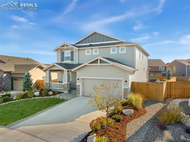 8032 Wheatland Dr, Colorado Springs, CO 80908 - craftsman-style house with concrete driveway, board and batten siding, a garage, fence, and covered porch