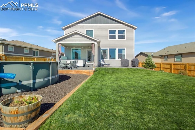 8032 Wheatland Dr, Colorado Springs, CO 80908 - back of property with a yard, a patio area, board and batten siding, a fenced backyard, and a fenced in pool