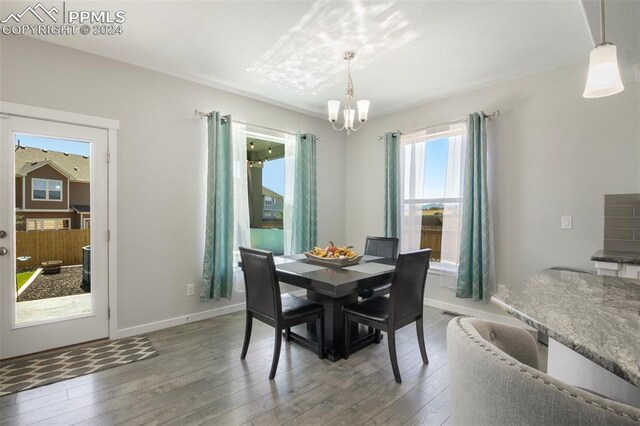 8032 Wheatland Dr, Colorado Springs, CO 80908 - dining area featuring a chandelier, wood finished floors, and baseboards
