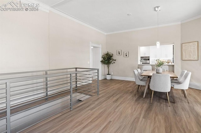 dining area with ornamental molding and light hardwood / wood-style floors