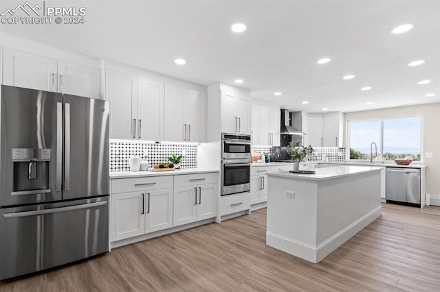 kitchen with white cabinets, stainless steel appliances, and light hardwood / wood-style flooring