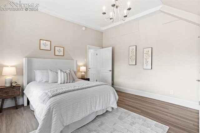 bedroom featuring light hardwood / wood-style flooring and an inviting chandelier