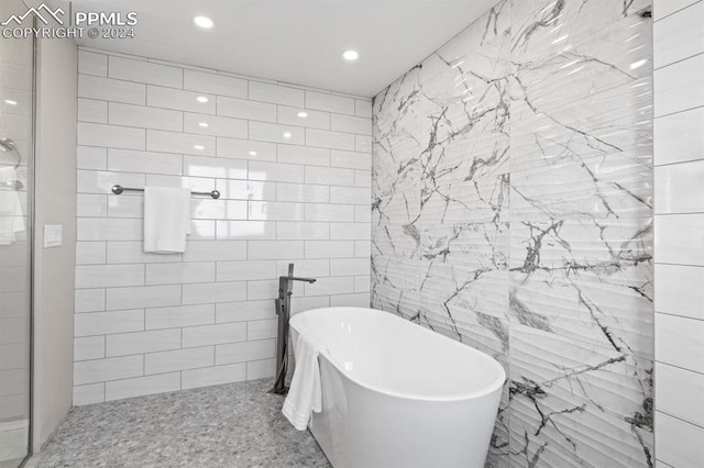 bathroom with a bath and tile walls