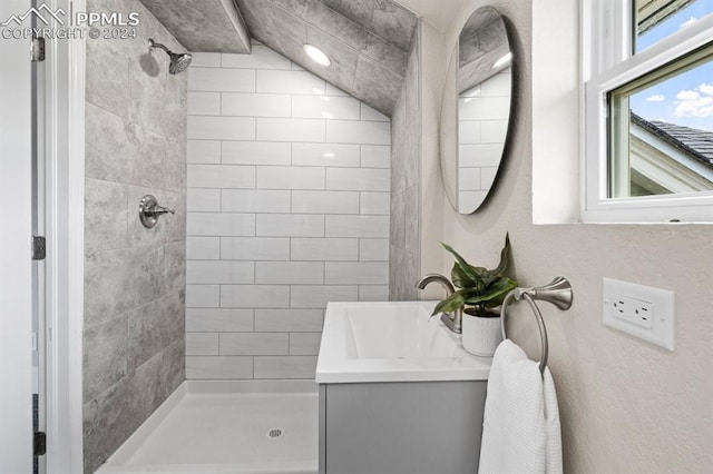 bathroom featuring tiled shower and vanity