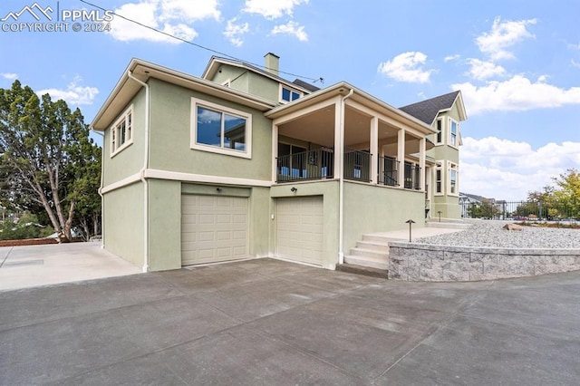 view of front of property featuring a balcony and a garage