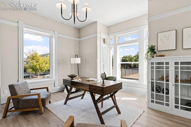 home office with a notable chandelier, light hardwood / wood-style floors, and a wealth of natural light