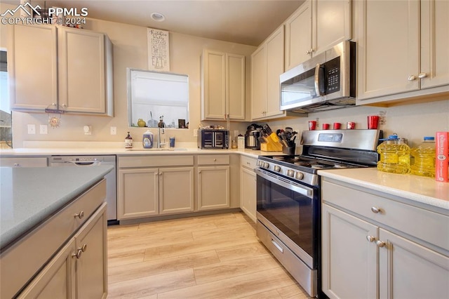 kitchen featuring sink, appliances with stainless steel finishes, and light hardwood / wood-style floors