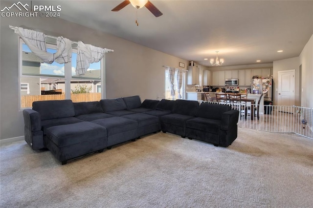 living room with light colored carpet, ceiling fan with notable chandelier, and plenty of natural light