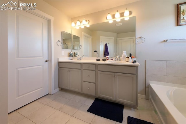 bathroom with a bath, tile patterned flooring, and vanity