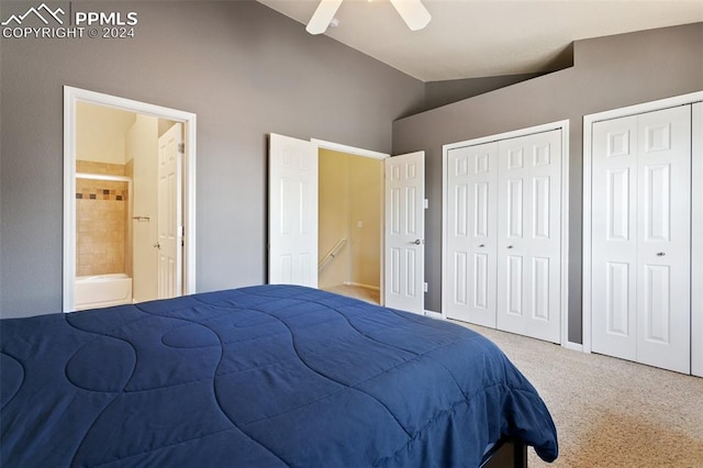 bedroom with carpet flooring, vaulted ceiling, multiple closets, ensuite bath, and ceiling fan