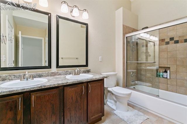 full bathroom with enclosed tub / shower combo, vanity, toilet, and tile patterned floors