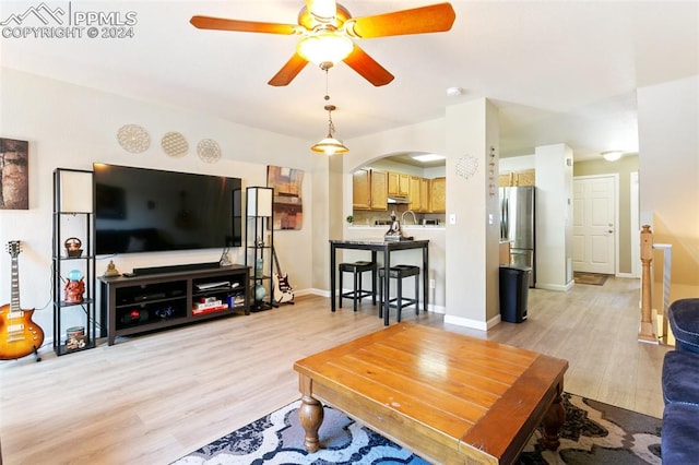 living room with ceiling fan and light hardwood / wood-style floors