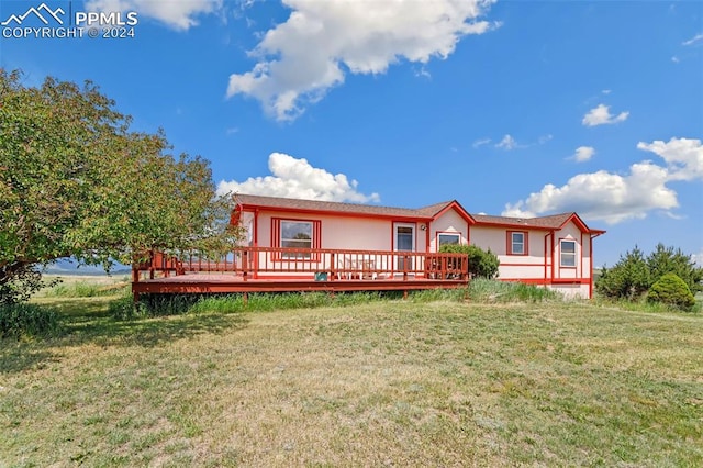 view of front of house with a front yard and a deck