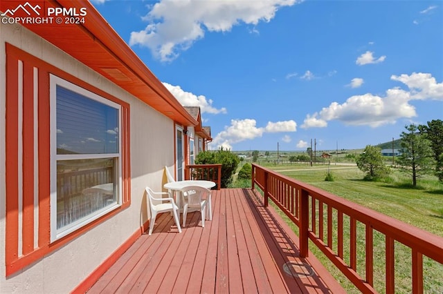 wooden terrace featuring a lawn