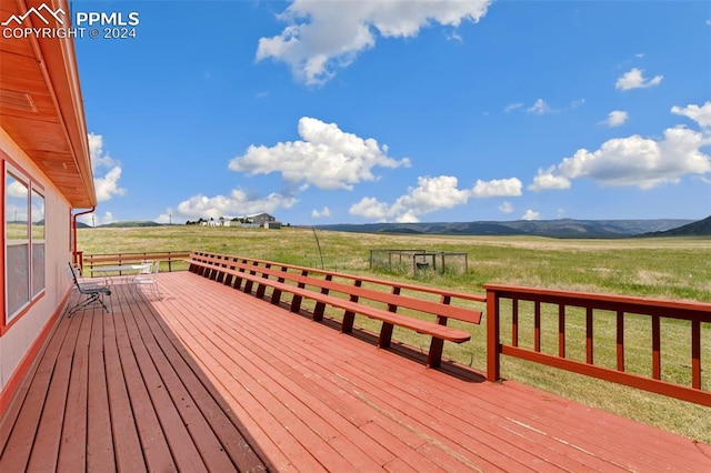 deck with a lawn, a mountain view, and a rural view