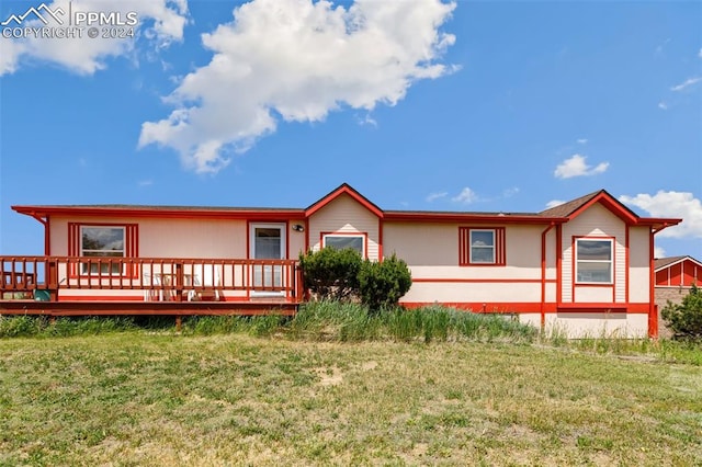 rear view of property with a lawn and a deck