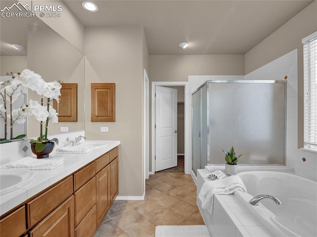 bathroom featuring plus walk in shower, a wealth of natural light, tile patterned flooring, and vanity