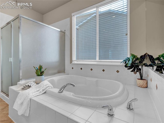 bathroom with plus walk in shower, plenty of natural light, and tile patterned floors