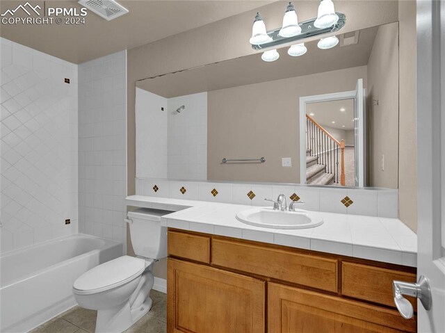 full bathroom featuring tiled shower / bath combo, tile patterned flooring, vanity, and toilet