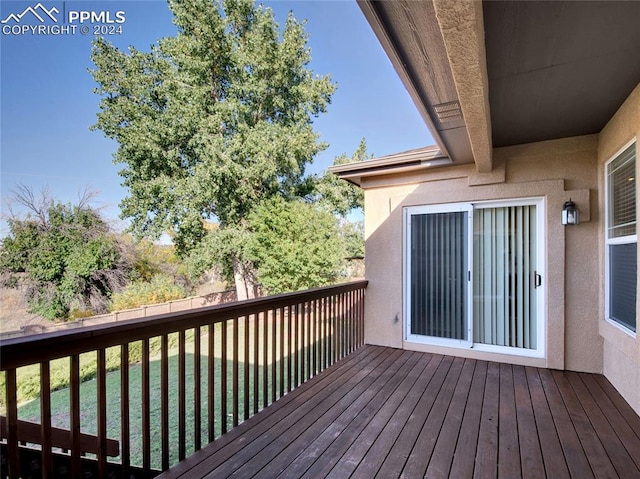 wooden deck featuring a lawn