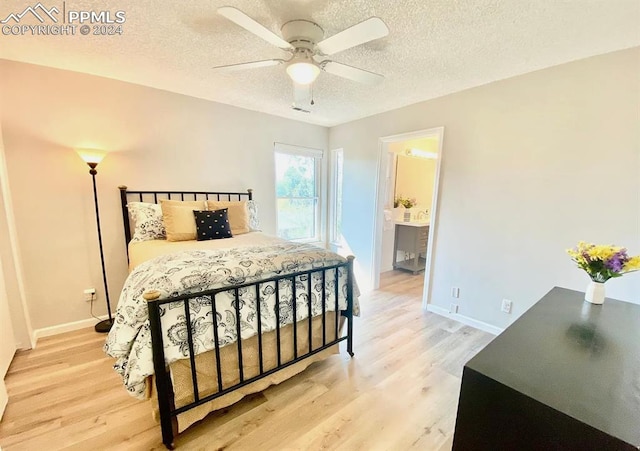 bedroom with ceiling fan, hardwood / wood-style flooring, ensuite bath, and a textured ceiling