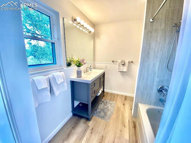 bathroom with tiled shower / bath, vanity, and hardwood / wood-style floors