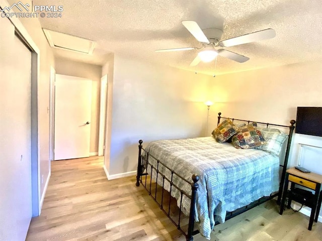 bedroom with ceiling fan, a textured ceiling, and light wood-type flooring