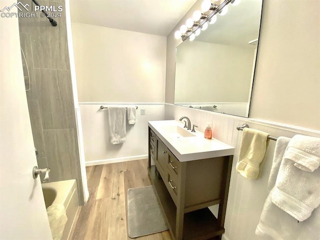 bathroom featuring tiled shower / bath, vanity, and wood-type flooring