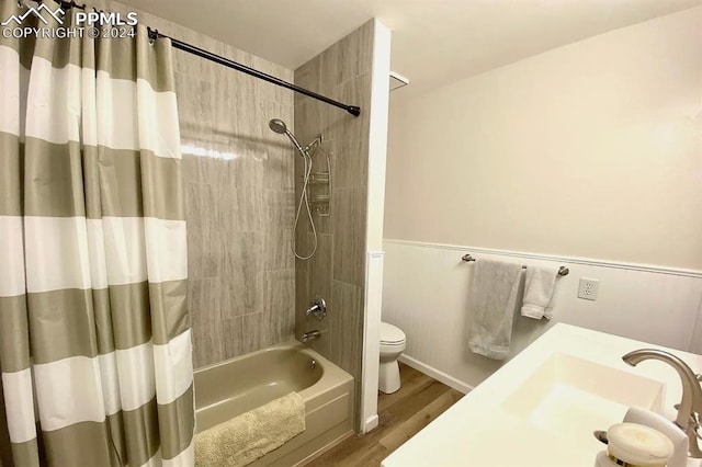 full bathroom with wood-type flooring, shower / bath combination with curtain, vanity, and toilet