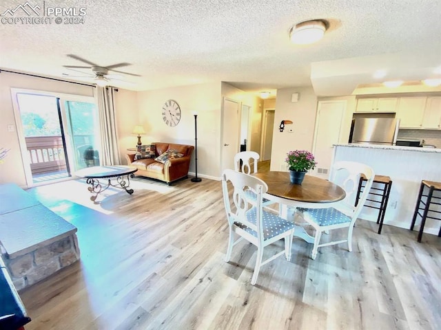 dining space featuring ceiling fan, a textured ceiling, and light hardwood / wood-style flooring