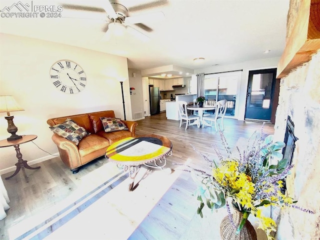 living room with ceiling fan and dark hardwood / wood-style flooring