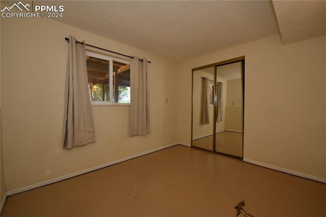 spare room with a textured ceiling and concrete floors